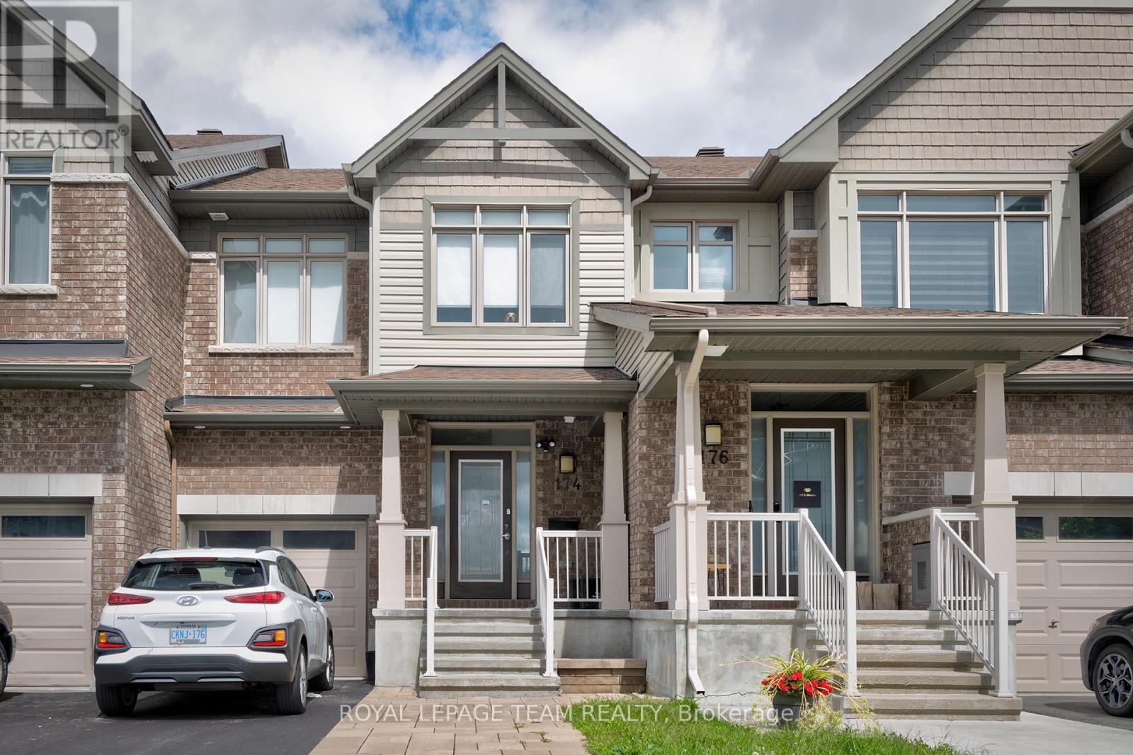 A white car is parked in front of a house.