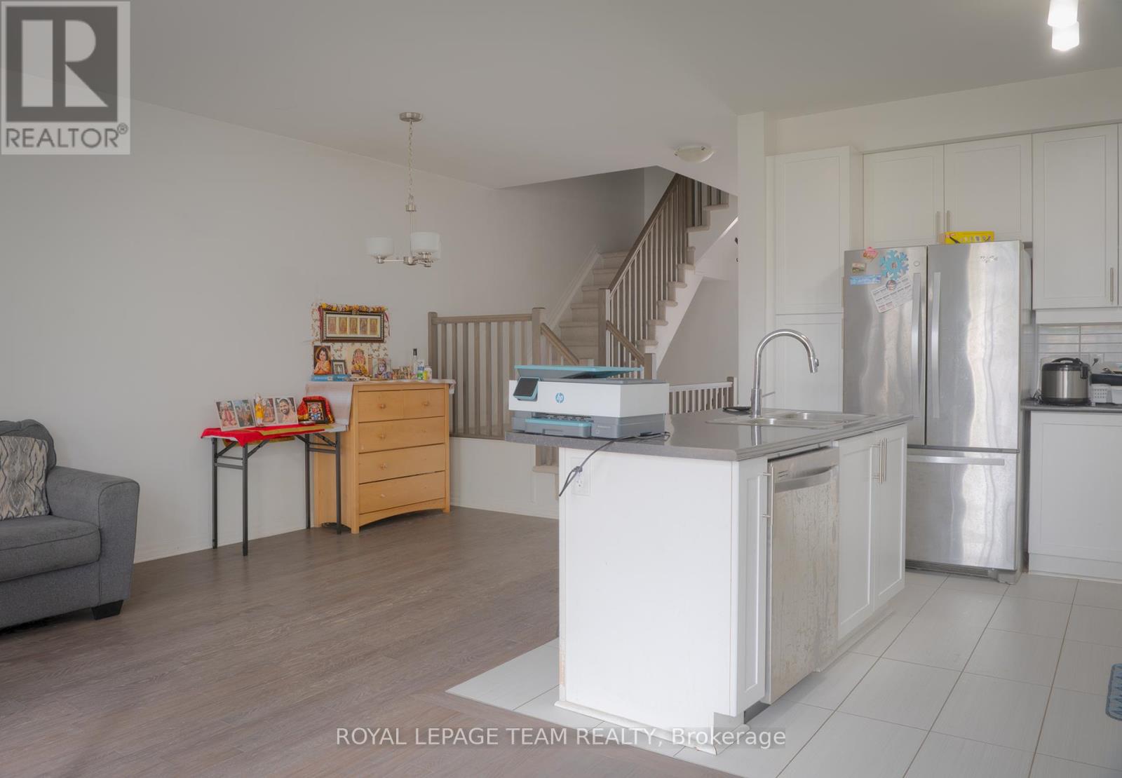 A kitchen with a refrigerator, sink, and stove is shown in this image.