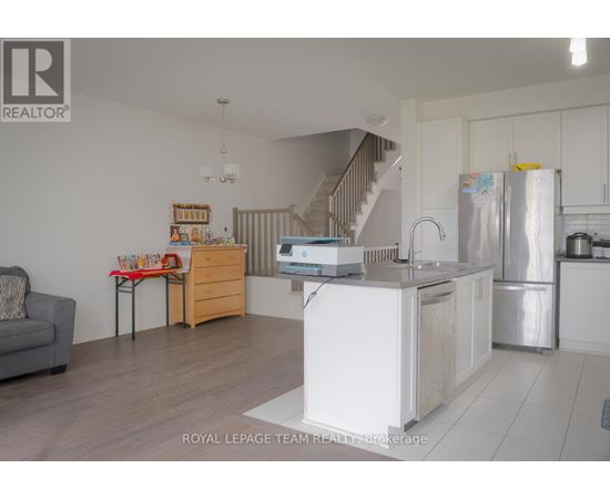A kitchen with a refrigerator, sink, and stove is shown in this image.