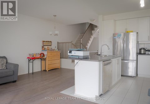 A kitchen with a refrigerator, sink, and stove is shown in this image.