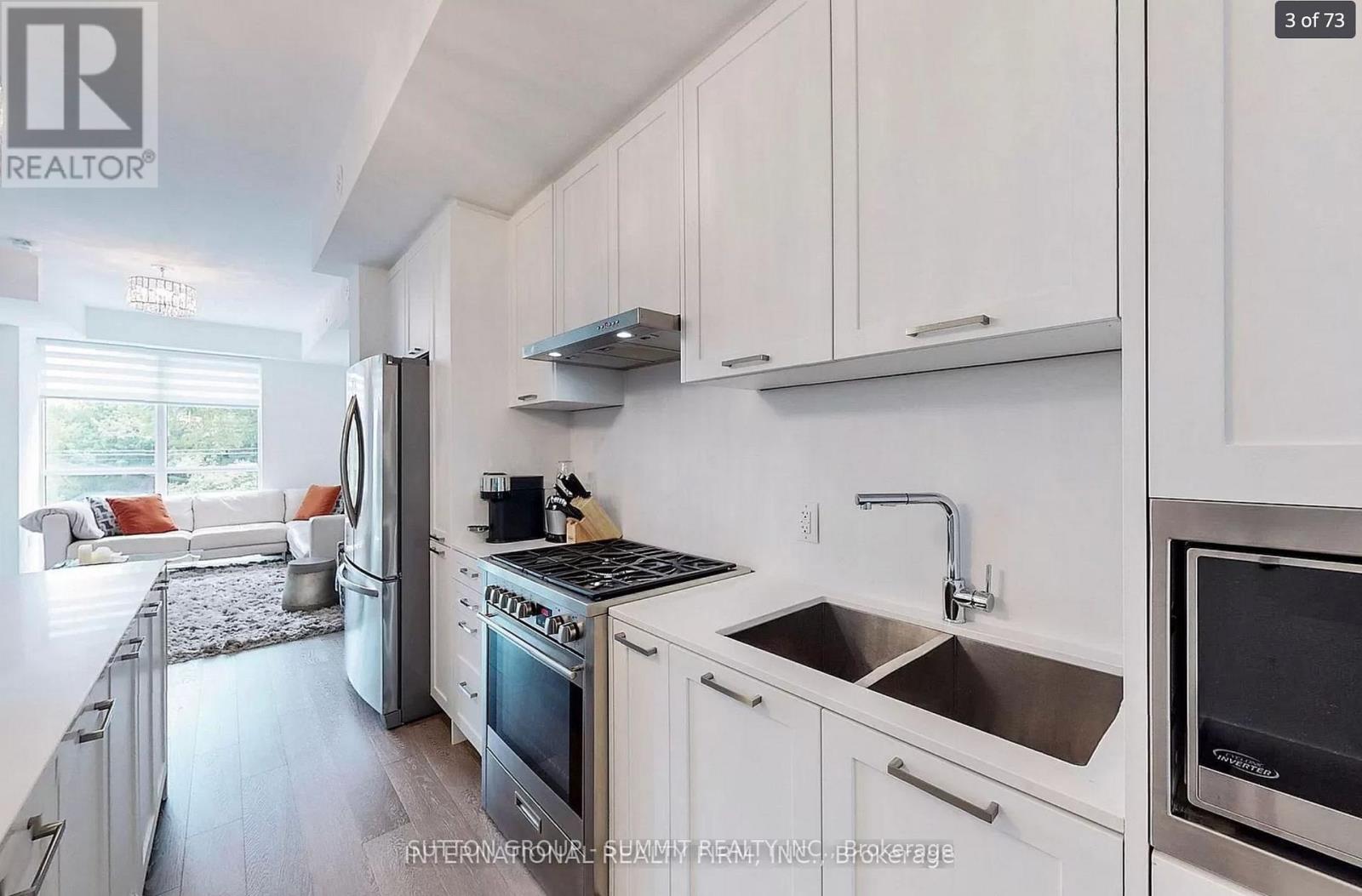 A modern kitchen with white cabinets and stainless steel appliances.
