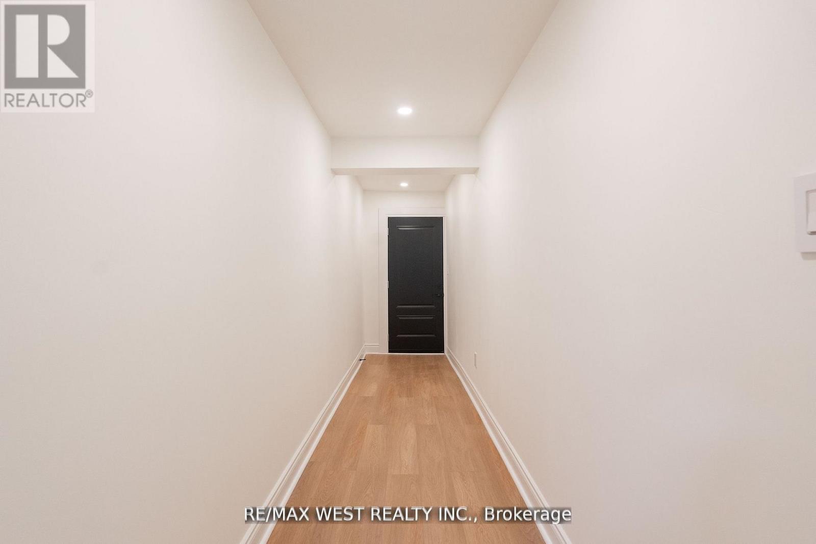A hallway with a black door at the end.
