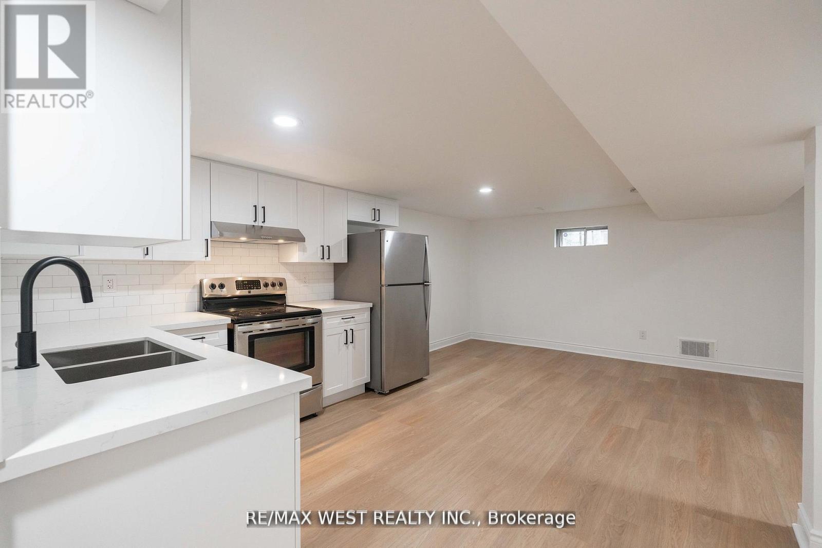 A kitchen with white cabinets and a stainless steel refrigerator.