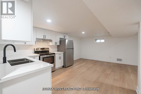 A kitchen with white cabinets and a stainless steel refrigerator.