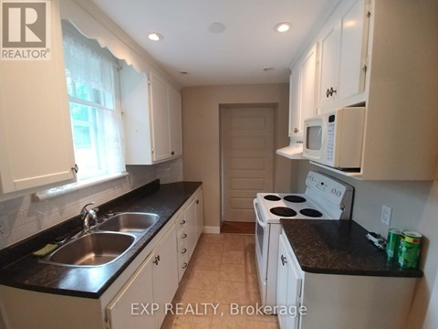A kitchen with white cabinets and a black countertop.