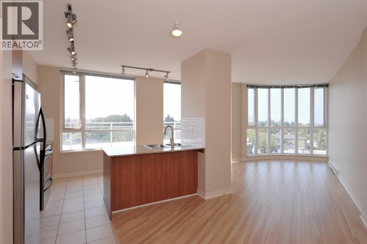 A spacious kitchen with wooden floors and a large window overlooking the outdoors.