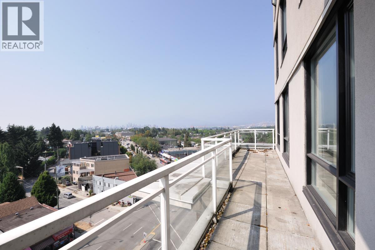 A balcony overlooks a city street and buildings.
