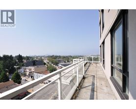 A balcony overlooks a city street and buildings.