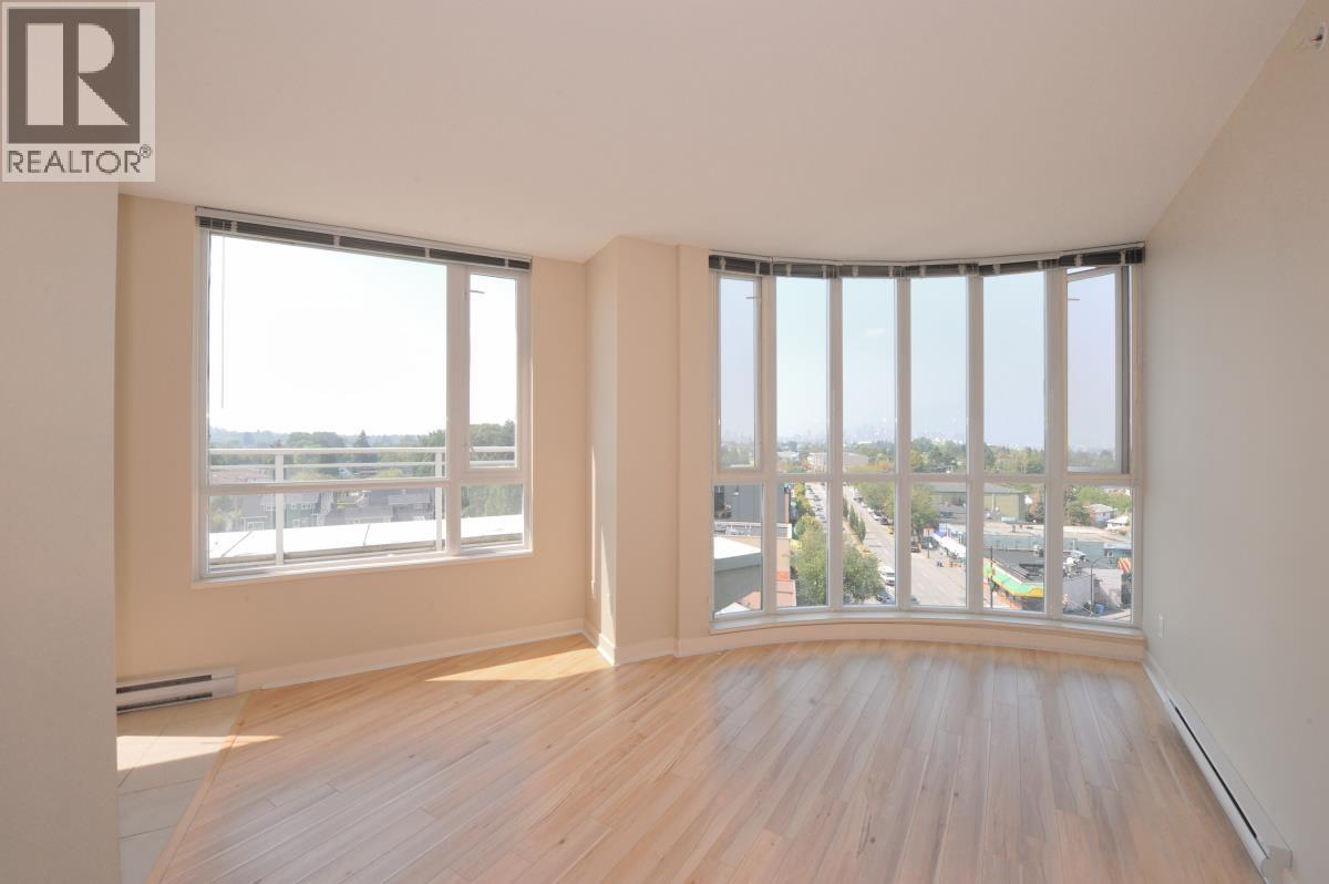 A large empty room with a view of the city through the windows.