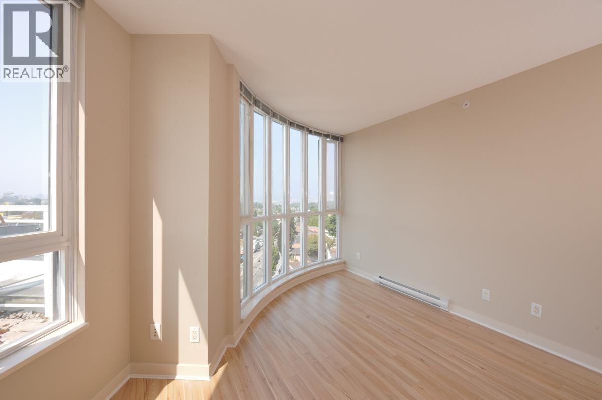 A room with a large window and wooden floors.
