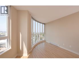 A room with a large window and wooden floors.