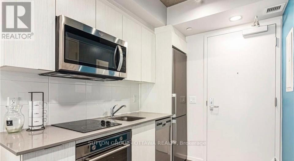 A modern kitchen with a stainless steel microwave above the stove.