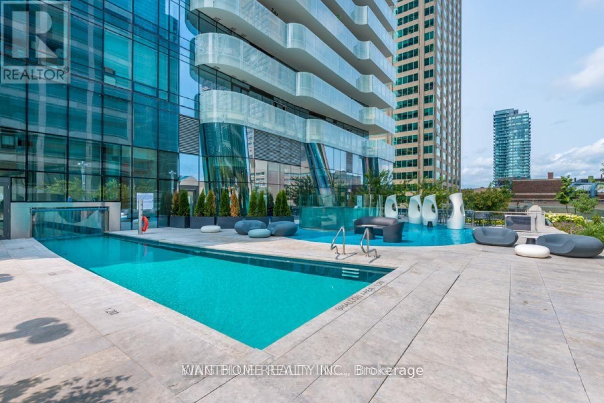 A modern pool area with a glass building in the background.