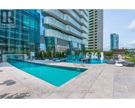 A modern pool area with a glass building in the background.