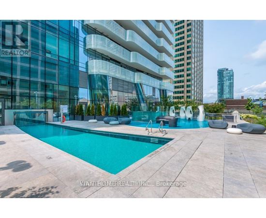 A modern pool area with a glass building in the background.