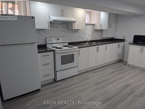 A kitchen with white cabinets and a white refrigerator.