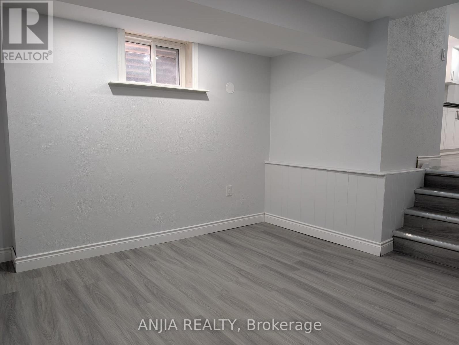 A room with a window and wooden flooring.
