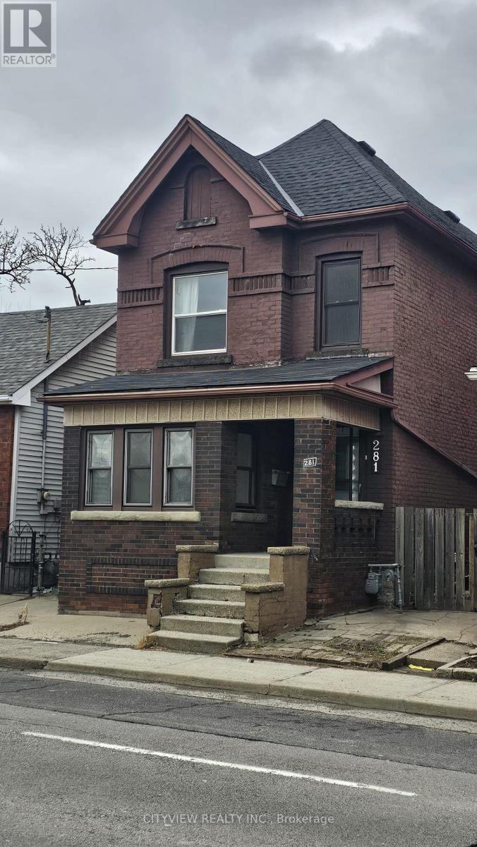 A brick house with a black roof and a white door.