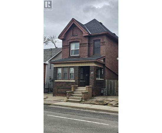 A brick house with a black roof and a white door.