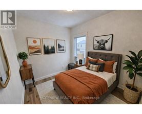A bedroom with a bed, nightstand, and pictures on the wall.