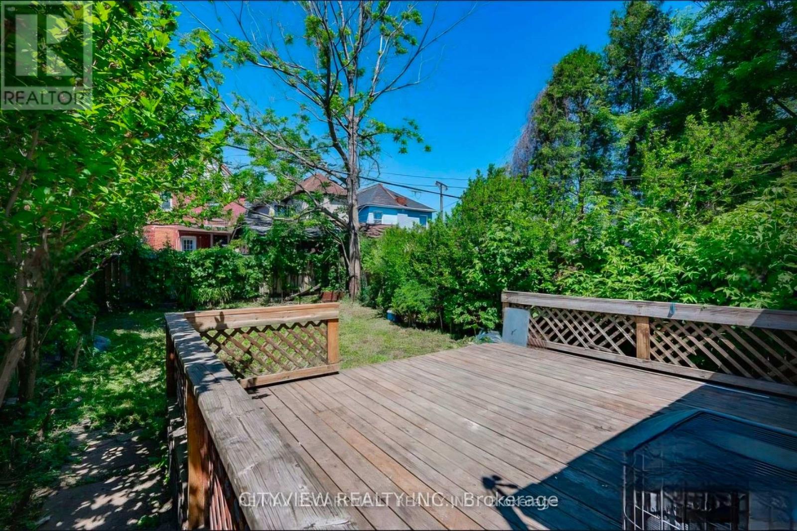 A wooden deck with a lattice fence and a pool in the foreground.