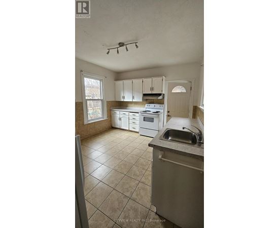 A kitchen with white cabinets and a stove top oven.
