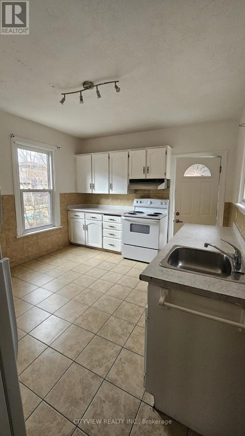A kitchen with white cabinets and a stove top oven.