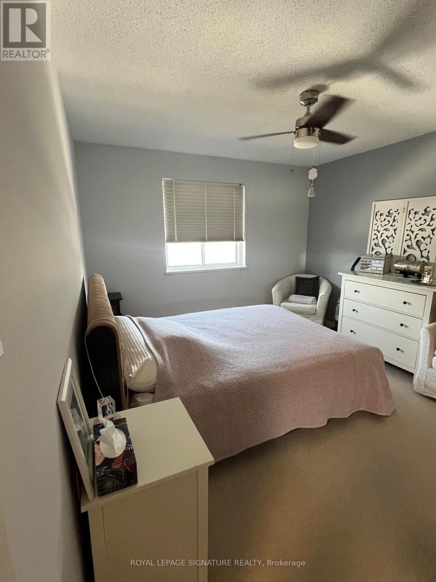 A bedroom with a bed, dresser, and window.