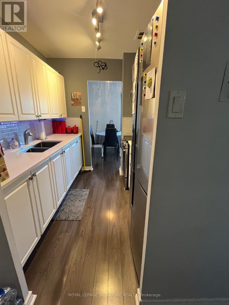 A kitchen with white cabinets and a wooden floor.