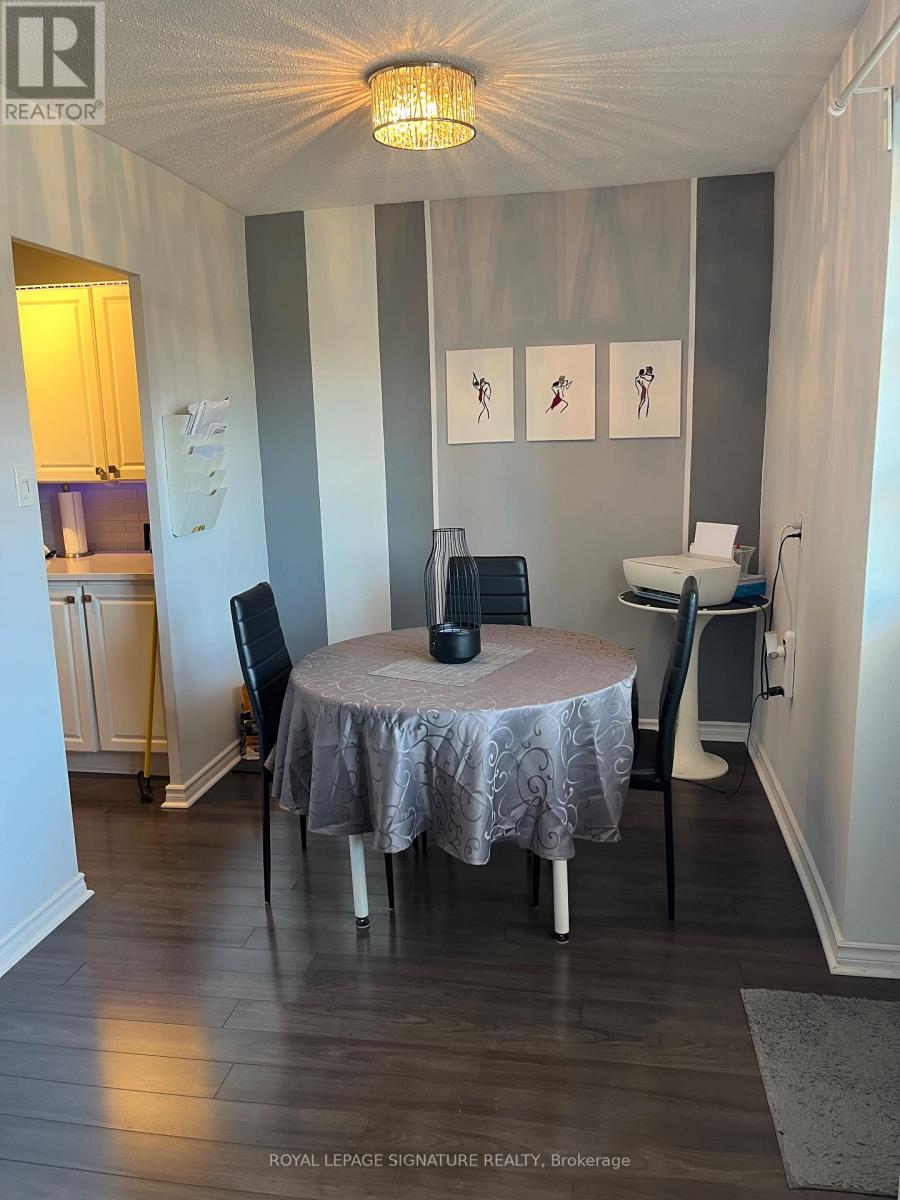 A dining room with a round table and chairs.