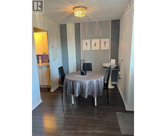 A dining room with a round table and chairs.