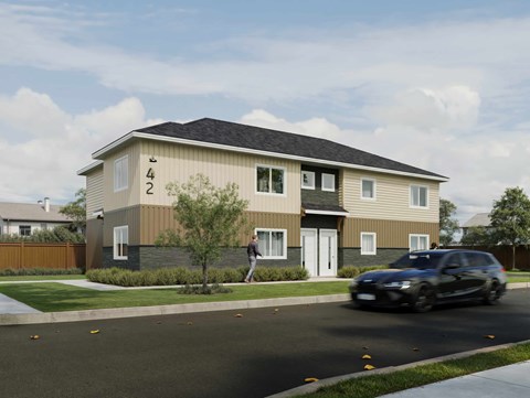 A car is driving past a two-story house with the number 422 on the front.