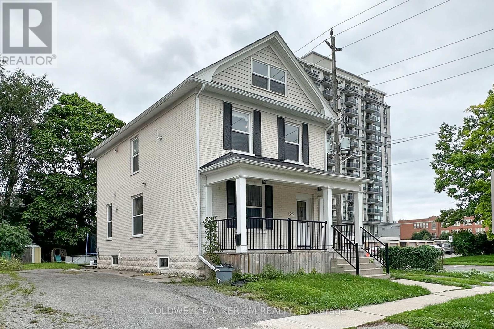 A two-story house with a front porch and a black railing.
