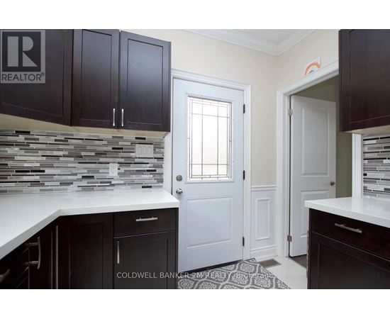 A kitchen with black cabinets and a stone backsplash.