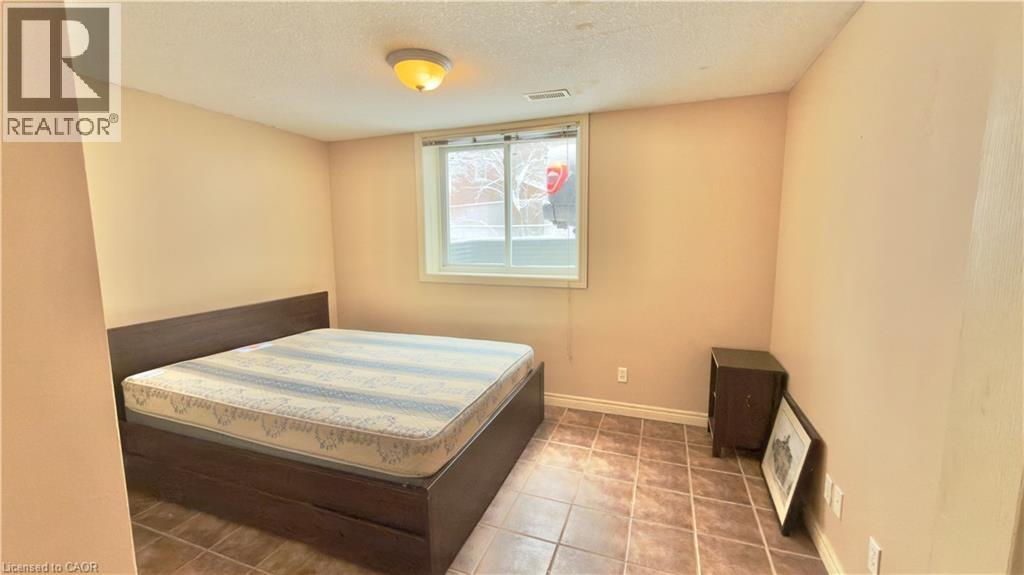 A bedroom with a bed, a small table, and a window.