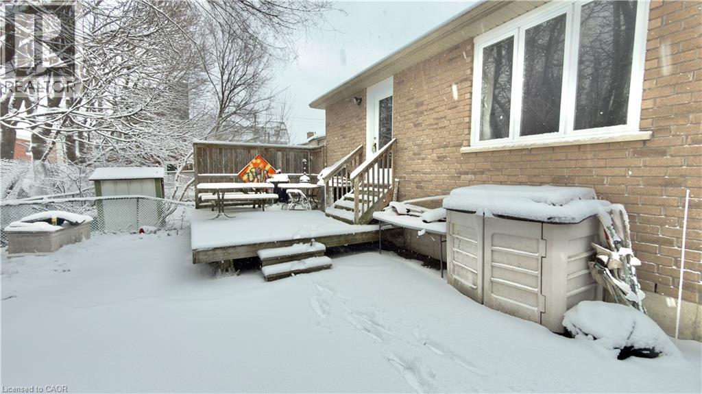 A snow-covered backyard with a deck and a hot tub.