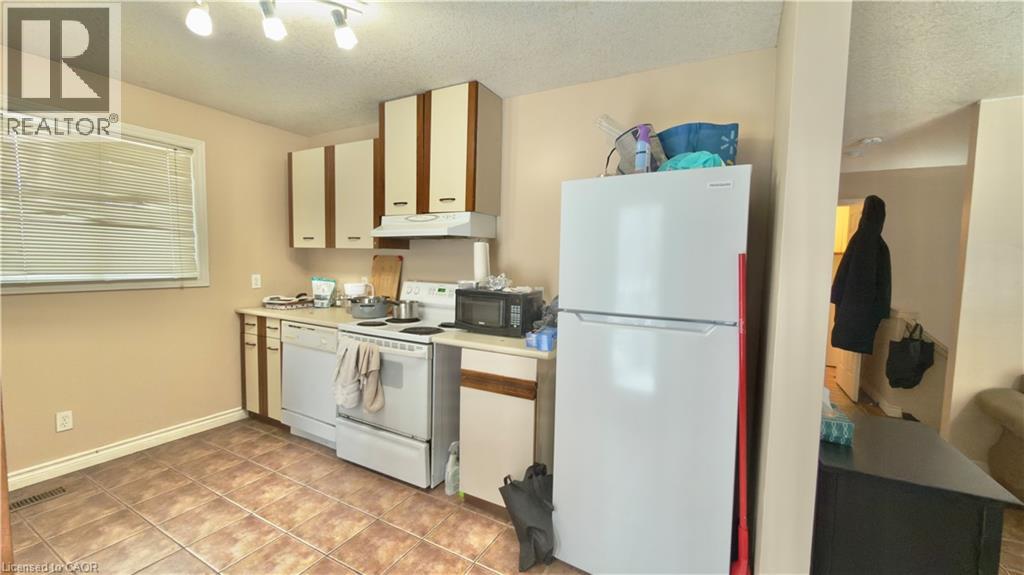 A kitchen with a white fridge and a white oven with a microwave above it.