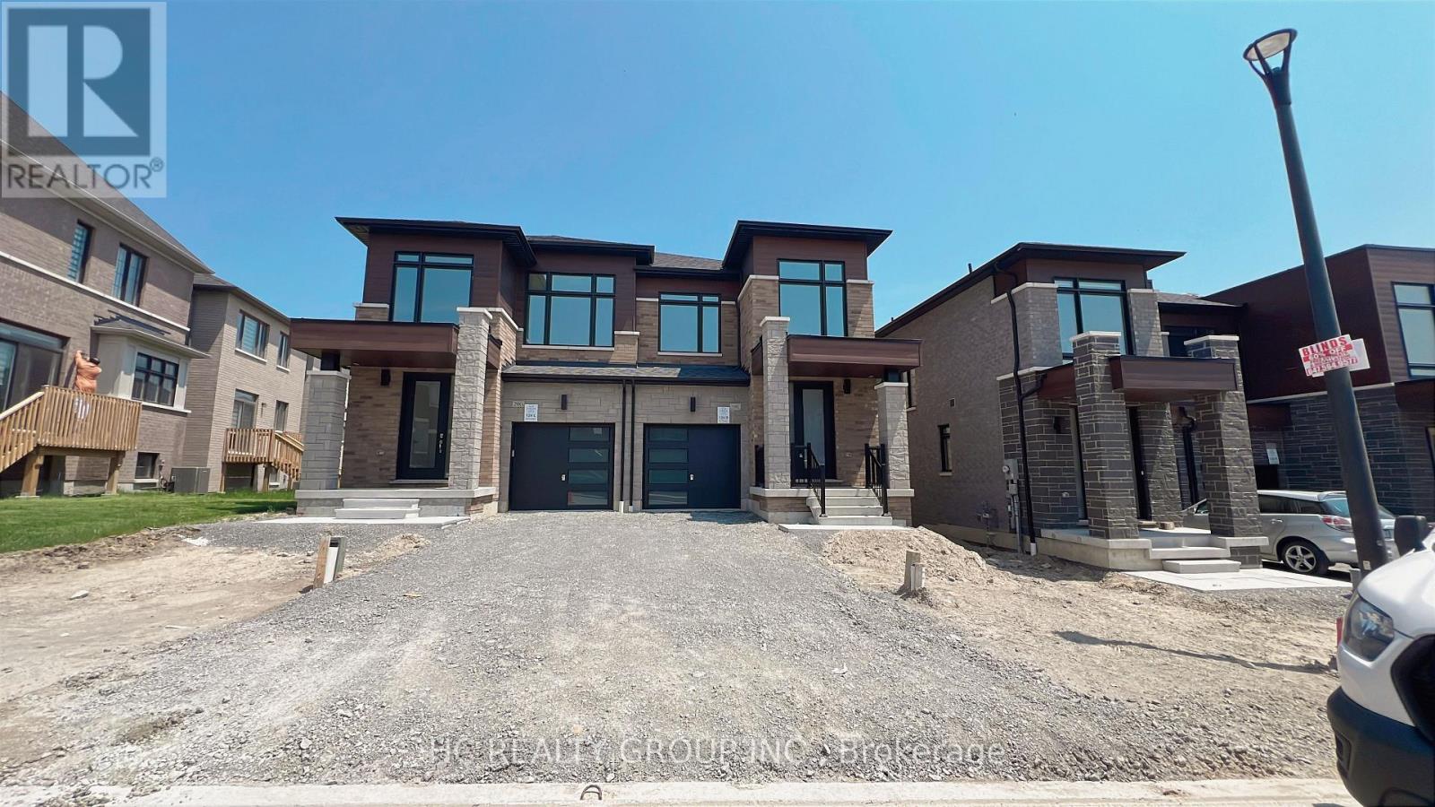 A house with a gravel driveway in front of it.