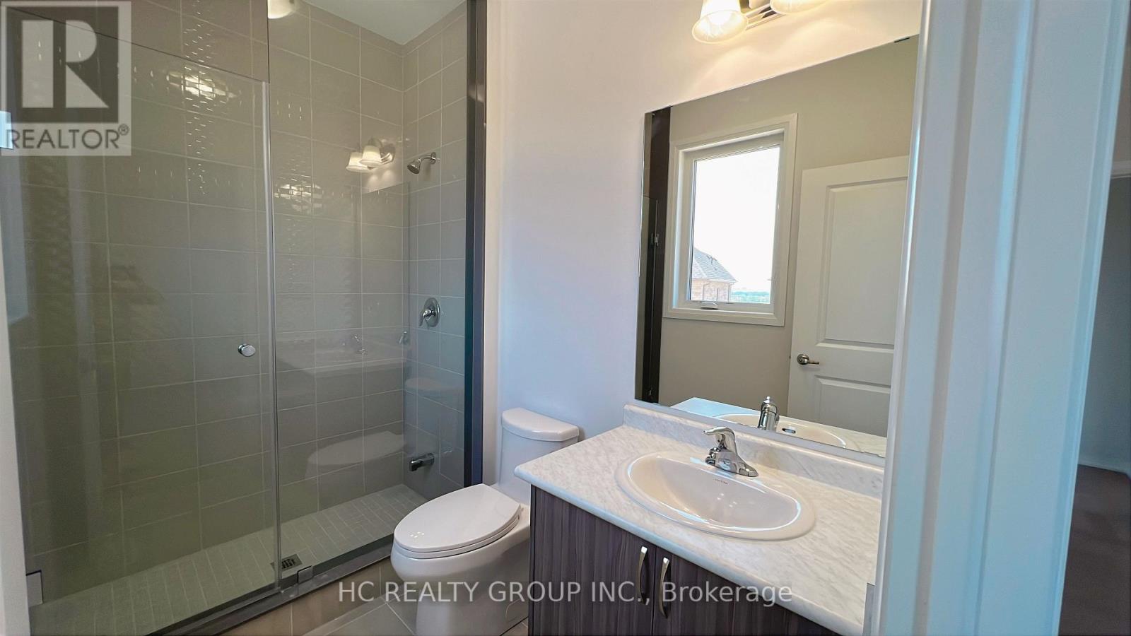 A bathroom with a sink, toilet and shower.