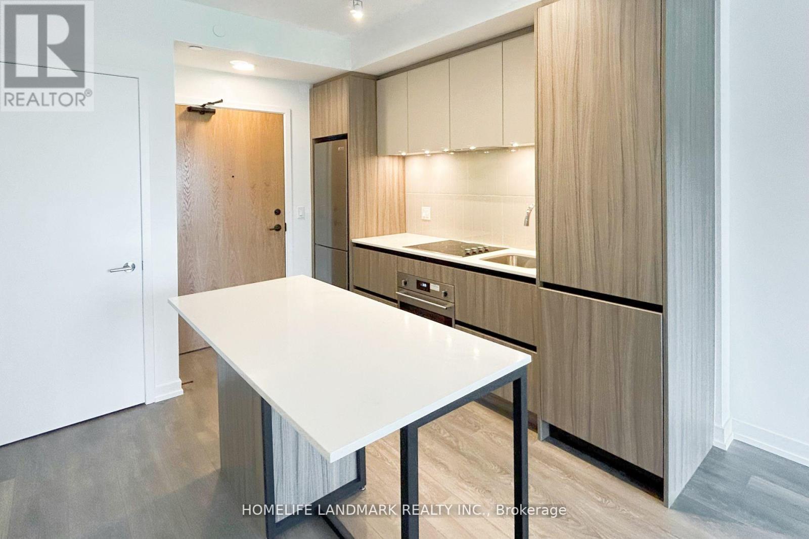 A modern kitchen with a white table and wooden cabinets.