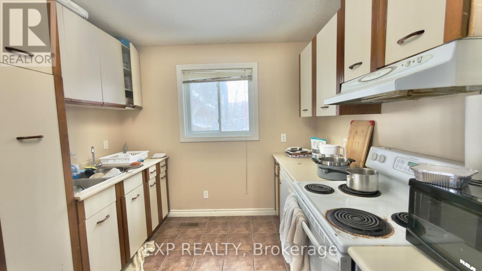 A kitchen with white cabinets and a window.