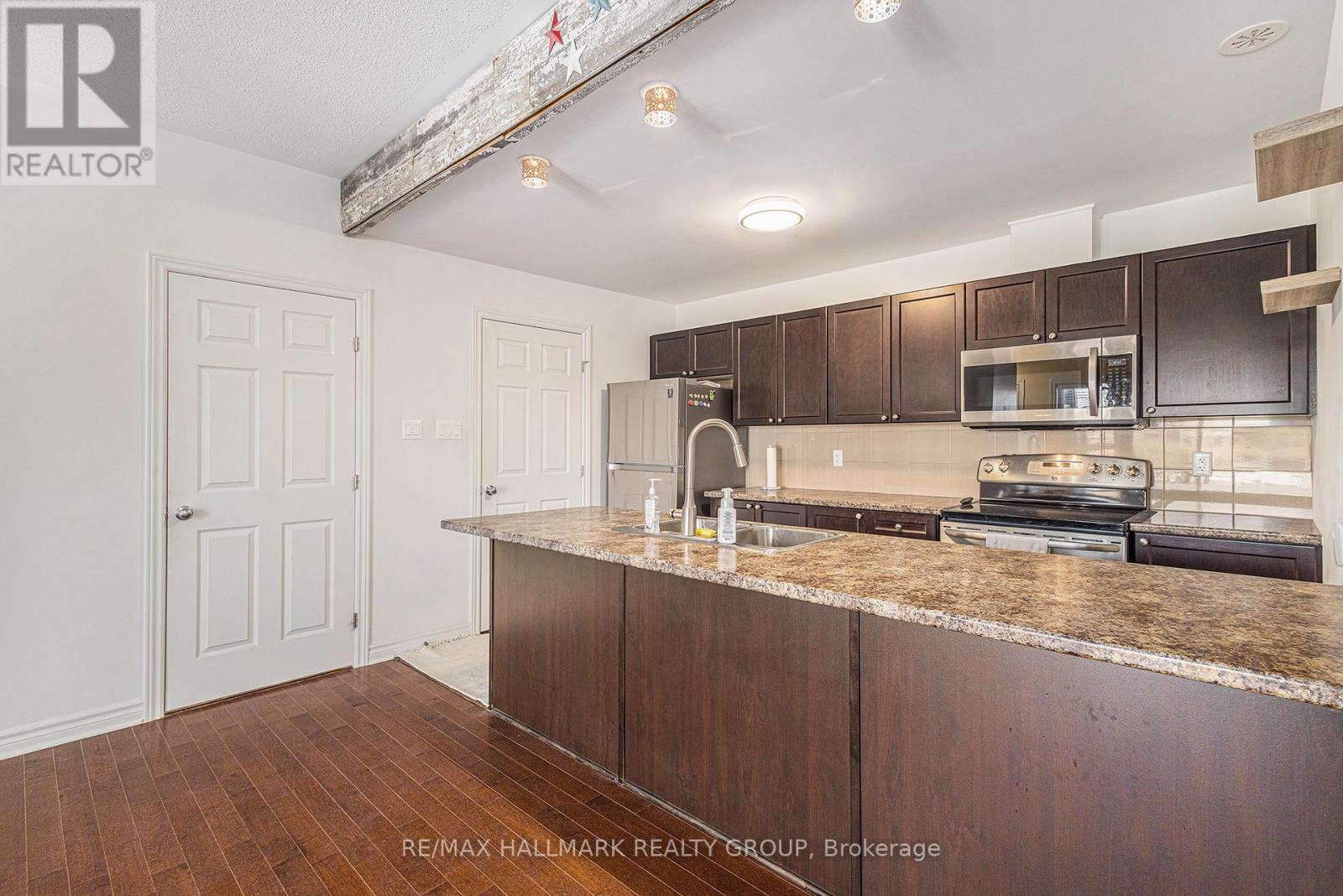 A kitchen with brown cabinets and a granite countertop.