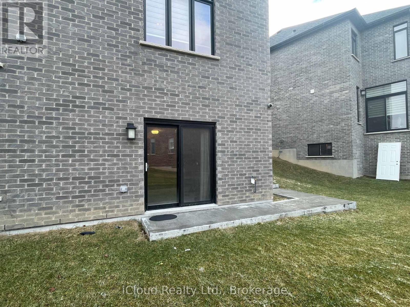 A brick building with a glass door and a sign that says "REALTOR".
