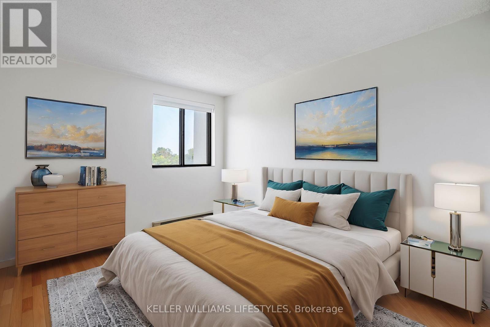 A bedroom with a bed, nightstand, and two pictures on the wall.