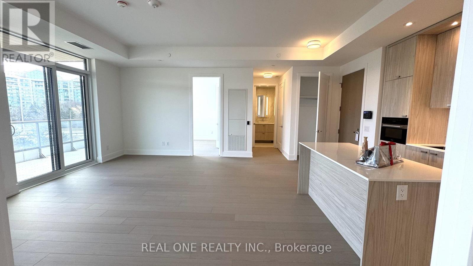 A spacious, well-lit room with a reception desk and a view of the outside through large windows.
