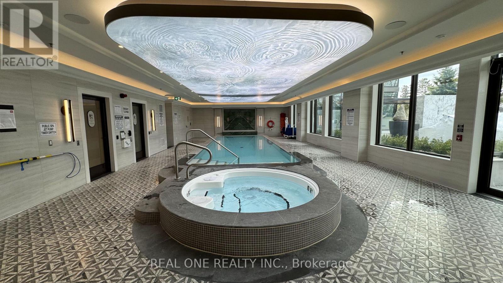 A large indoor swimming pool with a hot tub in the middle of a tiled floor.