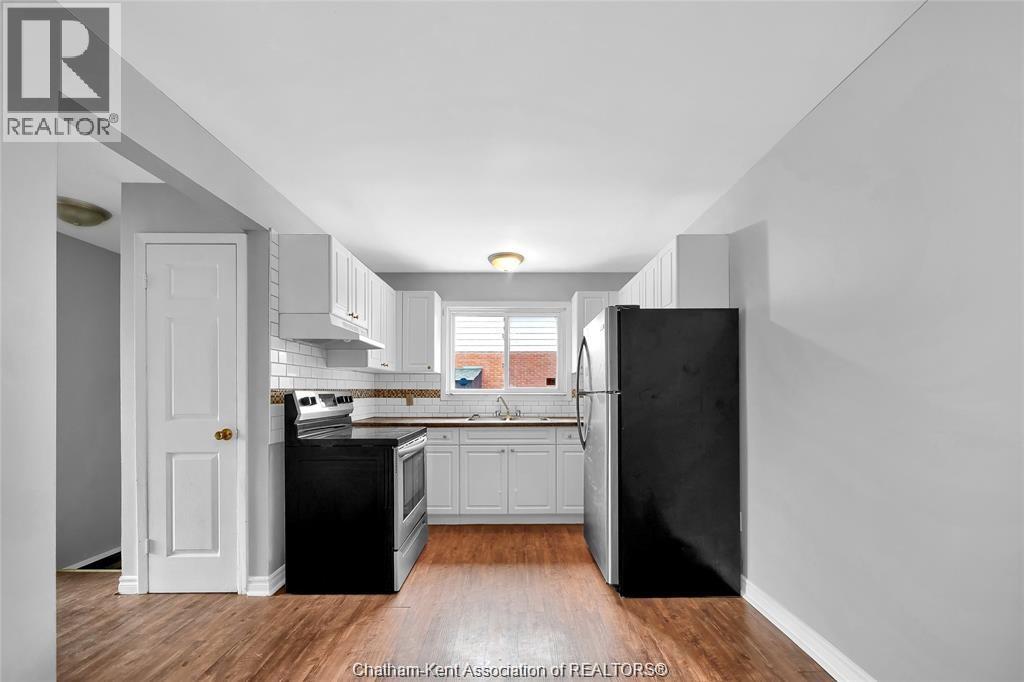 A kitchen with black appliances and white cabinetry.