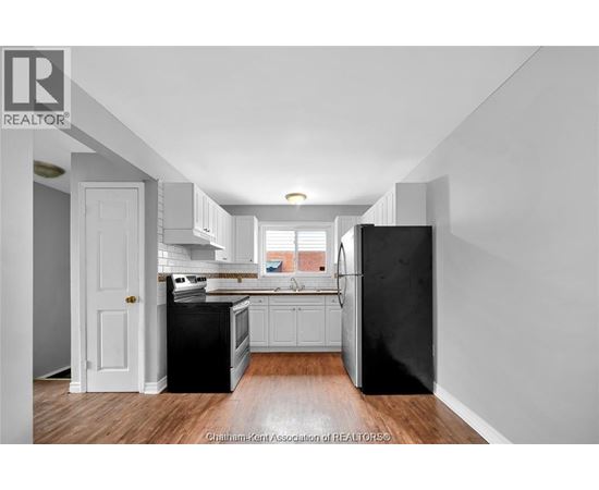 A kitchen with black appliances and white cabinetry.
