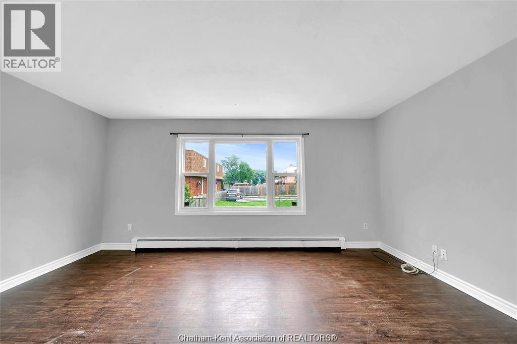 A room with a large window and wooden flooring.