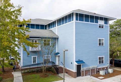 A blue two story house with a white door and windows.